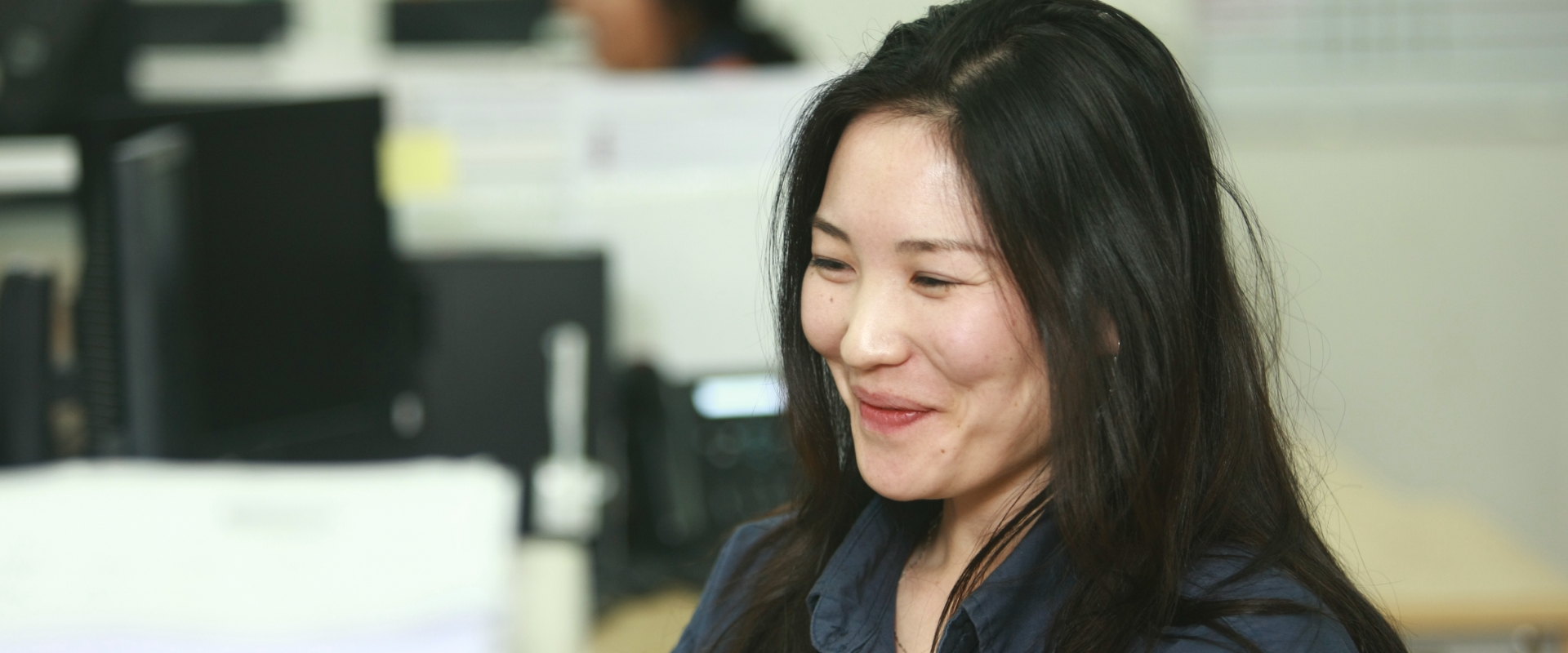 This photo shows a Redpath employee smiling and enjoying her office work.